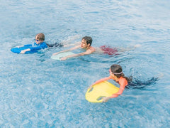 One adult and two kids in the pool with Asiwo Mako Electric Kickboards.