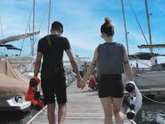 Two adults walking down pier with Asiwo Manta underwater scooters.