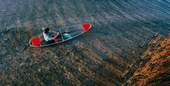 Aura Kayaking Adventurer Clear Kayak paddling on the water.