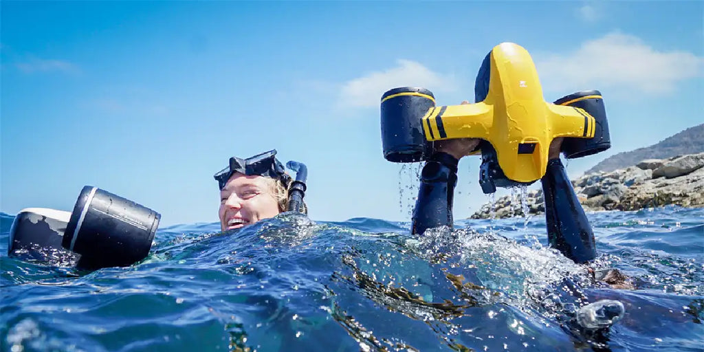 Seaflyer Robosea underwater scooters held above water by snorkelers.