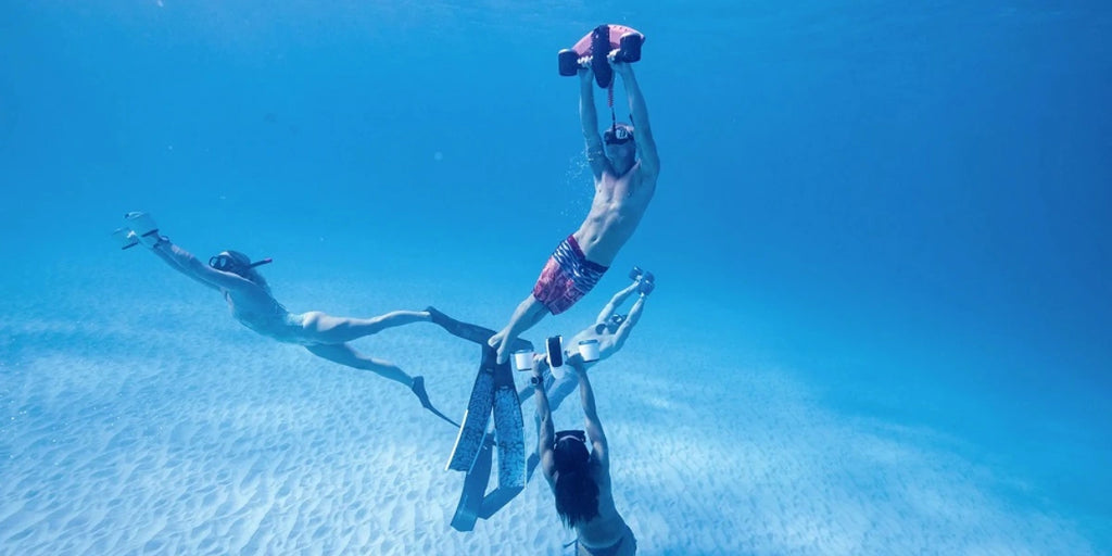 Adults under the water with Sublue underwater scooters.