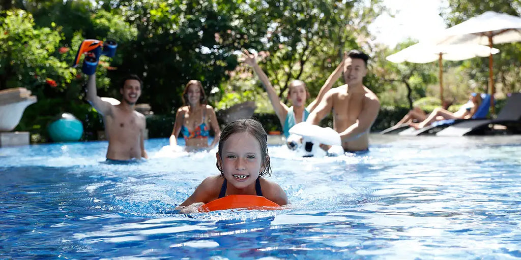 Adults and kid in the pool with Sublue underwater scooters.