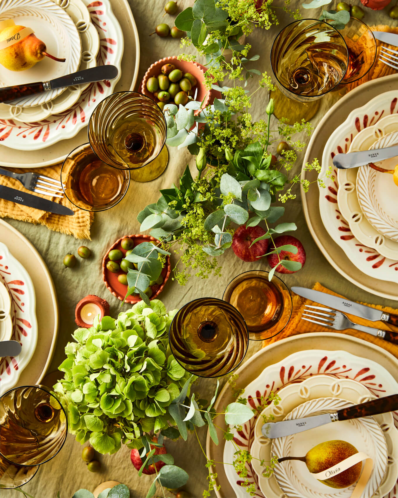 Autumnal centrepiece with green, orange, brown and rustic glasses and crockery