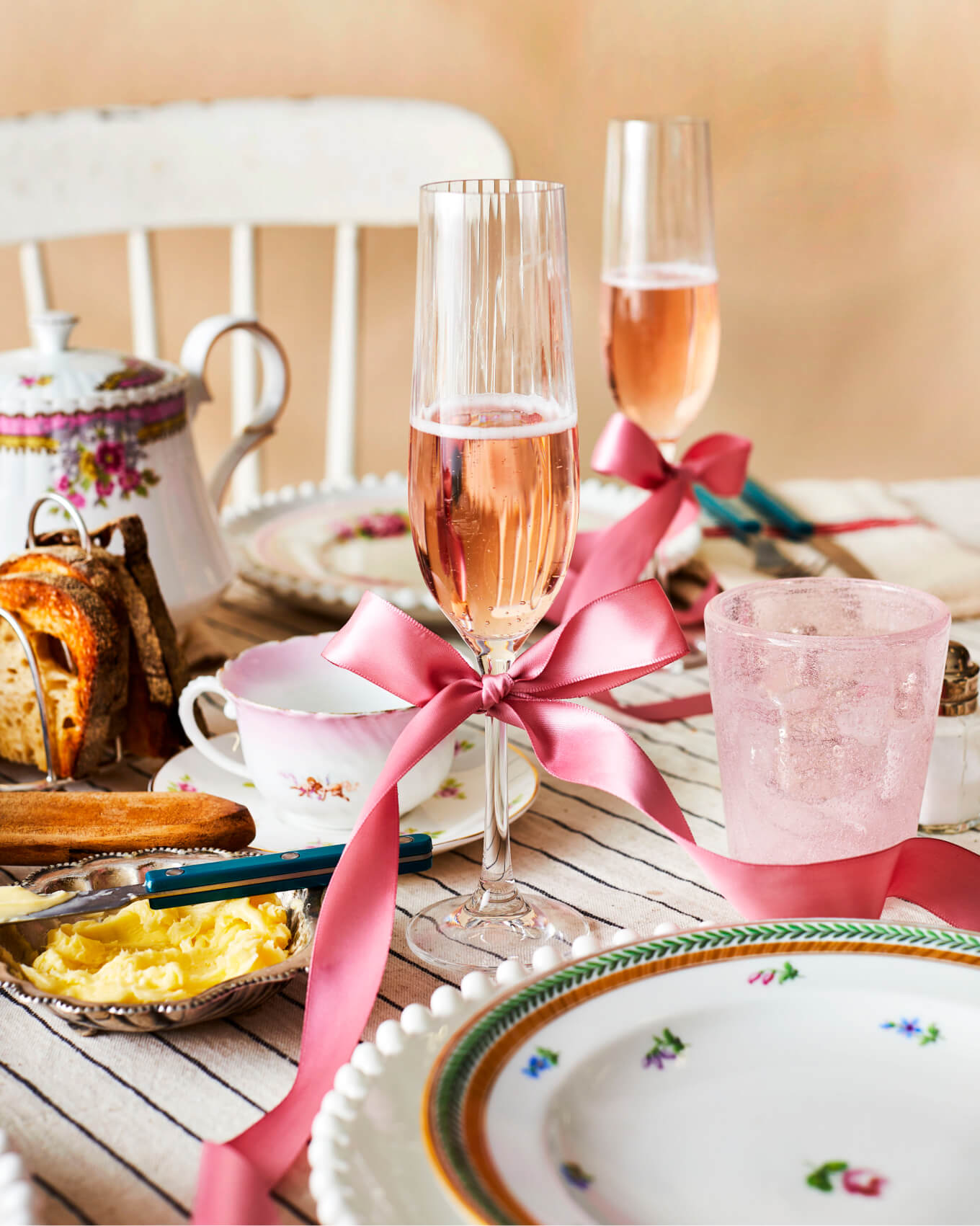 Pink champagne in flutes on a beautiful brunch table setting with vintage china