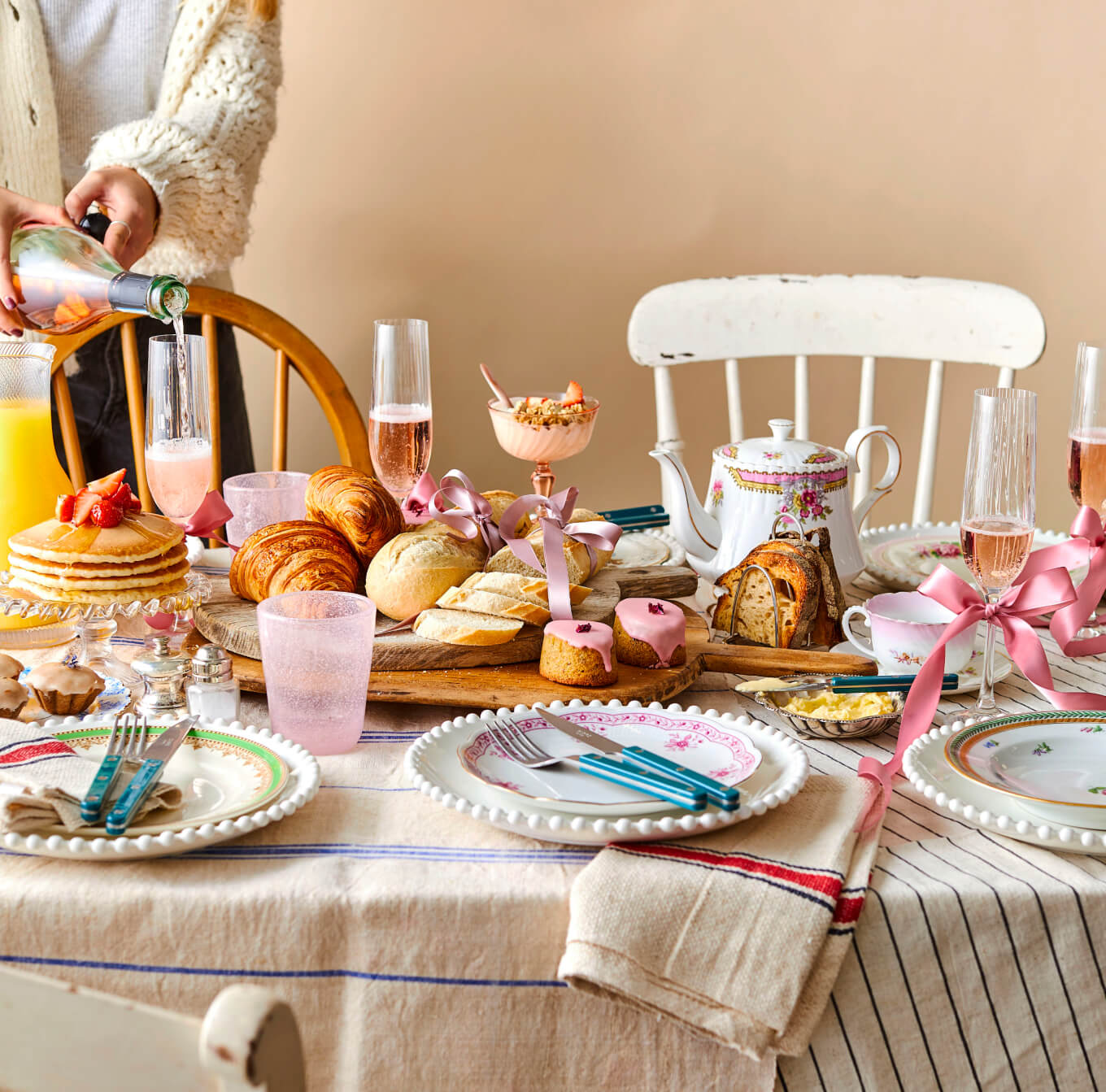 Beautiful brunch spread on a table with tea, cakes, champagne and vintage china
