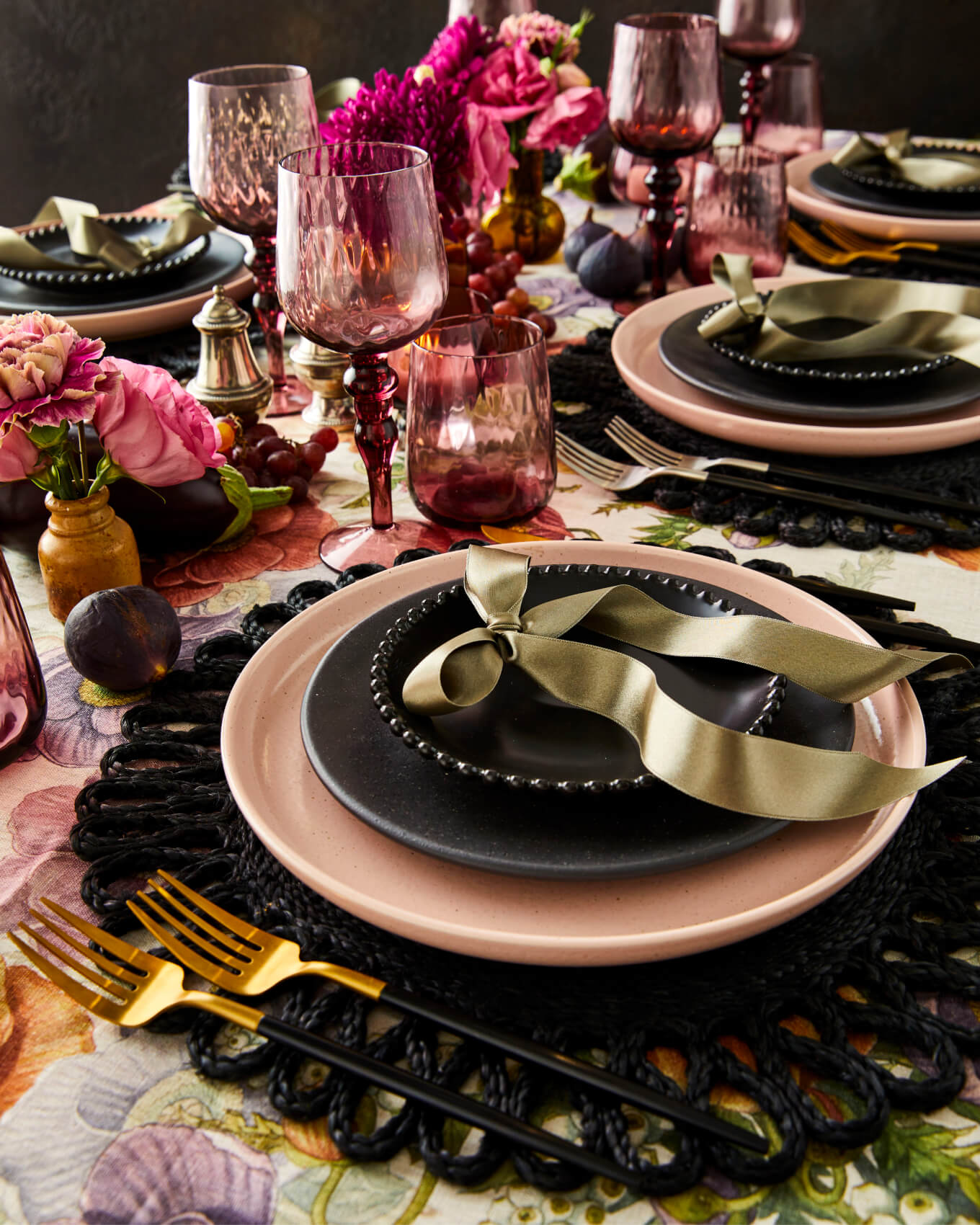 Black and pink Halloween place setting table styling with gold bows and ruby wine glasses