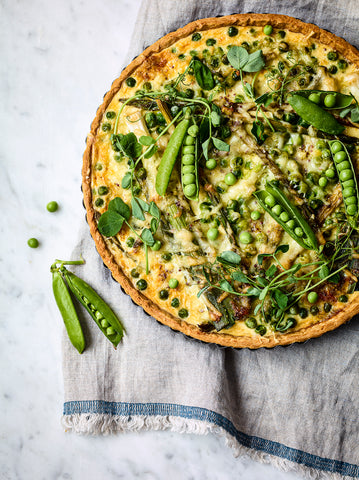 Spring Tart with Leeks, Asparagus & Peas, recipe from The Social Kitchen Table cookbook. "The Spring Tart with Leeks, Asparagus & Peas is a delicious addition to any garden party menu. Its vibrant colors and fresh flavors perfectly capture the essence of the season,