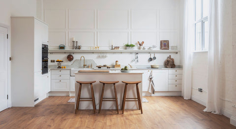 white shaker kitchen with tall ceiling and white linen curtains and brass details