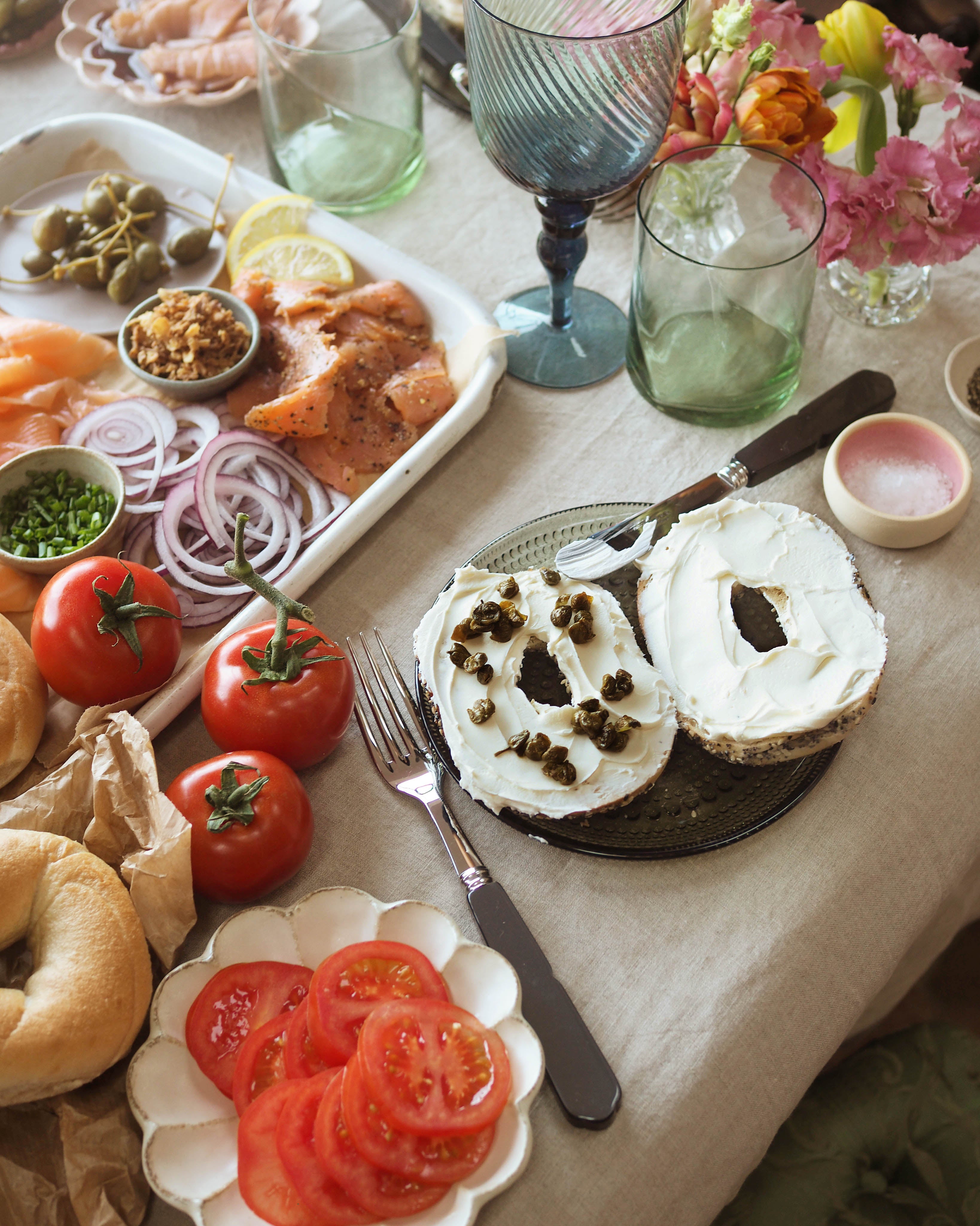 Bagel brunch table shot from above with salmon, gherkins, capers and cream cheese