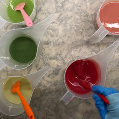 Pouring containers of coloured soap