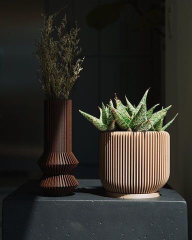 The brown modernist vase ZEPHYR and beige planter IONIC by Woodland Pulse.