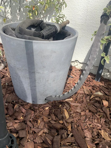 Flowerpot for hose storage.