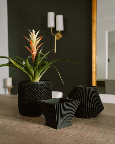 Three modern indoor planters by Woodland Pulse. These are unique black pots.