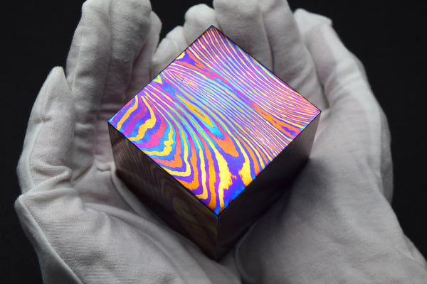 Holding a piece of 1-kilogram Timascus Cube
