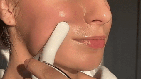 girl using face massage tool 