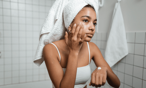 Woman Applying Cream on Face