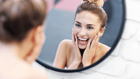 Woman Looking at Skin in Mirror