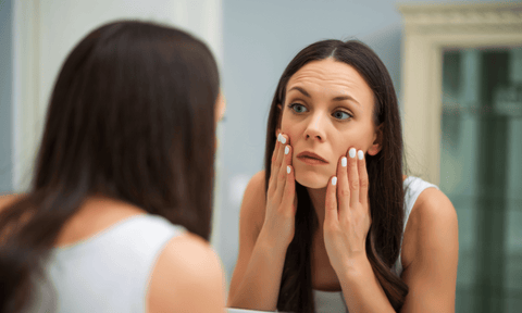 Woman Looking at Sticky Skin in Mirror