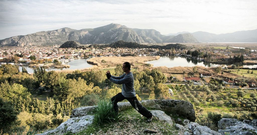 A man doing Tai Chi on a mountainside