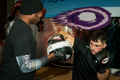 A photo of Barry Robinson holding pads from How to Train for World Level Boxing - Fighter Drills