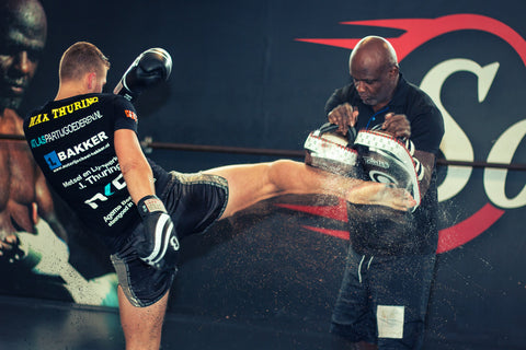 A photo of Ernesto Hoost training world level dutch kickboxing with one of his fighters
