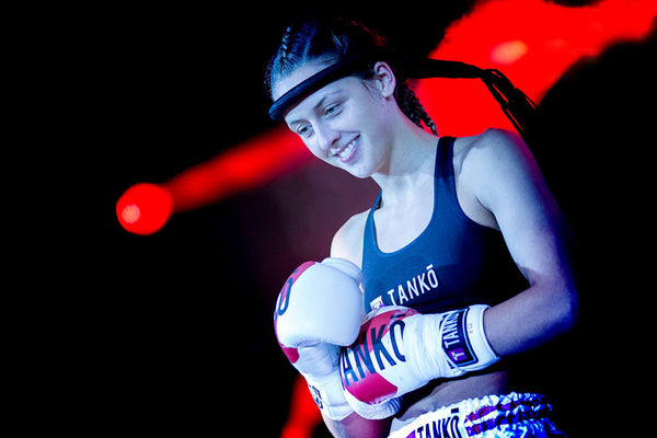 A photo of a female fighter in the ring from the blog post covering how to cope with pressure and performance anxiety in combat sports