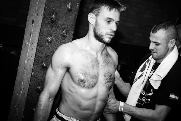 A photo of a coach warming up a fighter from the blog post exploring the psychology of winning fights in Martial arts and Combat Sports