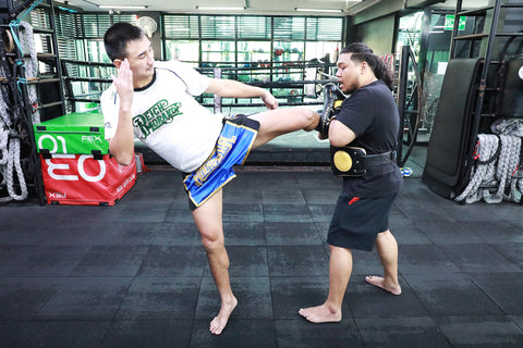 A photo of a coach and fighter demonstrating pad work at one of the best Bangkok Muay Thai gyms in Thailand