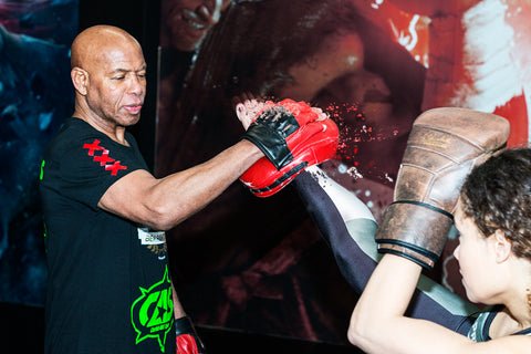 A photo of Lucien Carbin holding pads for one of his Carbin All Style Dutch Kickboxing Drills