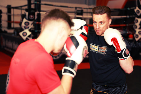 A photo of Mick Crossland demonstrating kickboxing sparring drills for developing fighters