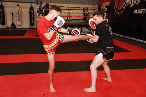 A photo of Mick Crossland demonstrating kickboxing sparring drills for developing fighters