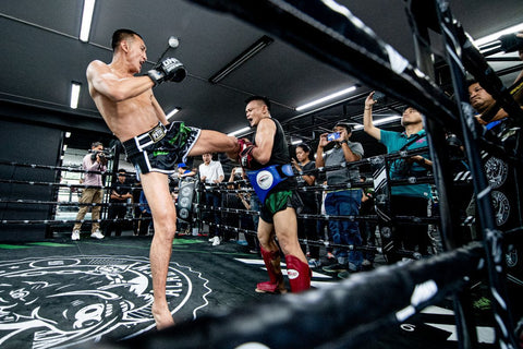 A photo of a coach and fighter demonstrating pad work at Petchyindee Kingdom, one of the best Bangkok Muay Thai gyms in Thailand
