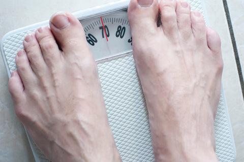 A photo of someone weighing themselves on scales from the Cutting Weight in Combat Sports Blog Post