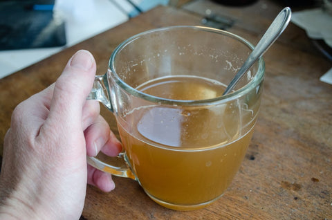 woman with a cup of warm chicken soup