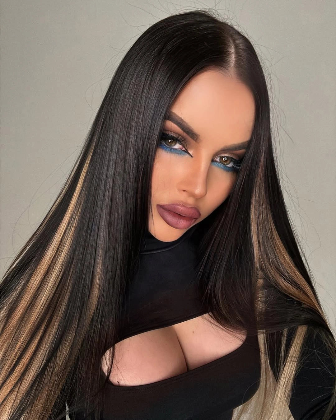 A close-up photo of a woman with long, dark hair featuring subtle ombre.