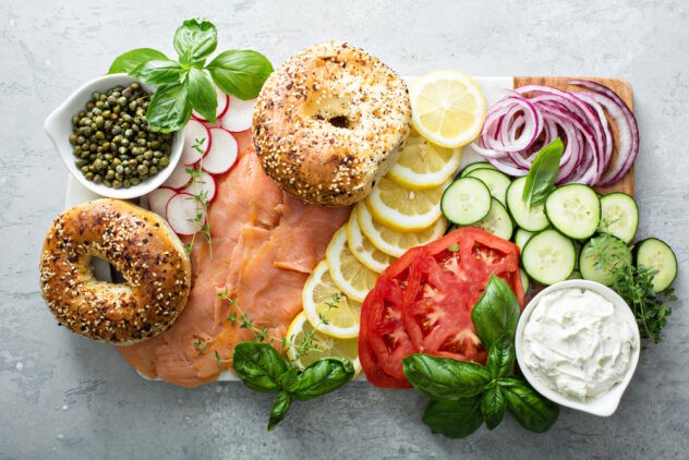 Pair wine with brunch – top-down view of an abundant lox plate with bagels, tomatoes, cucumbers, cream cheese and more