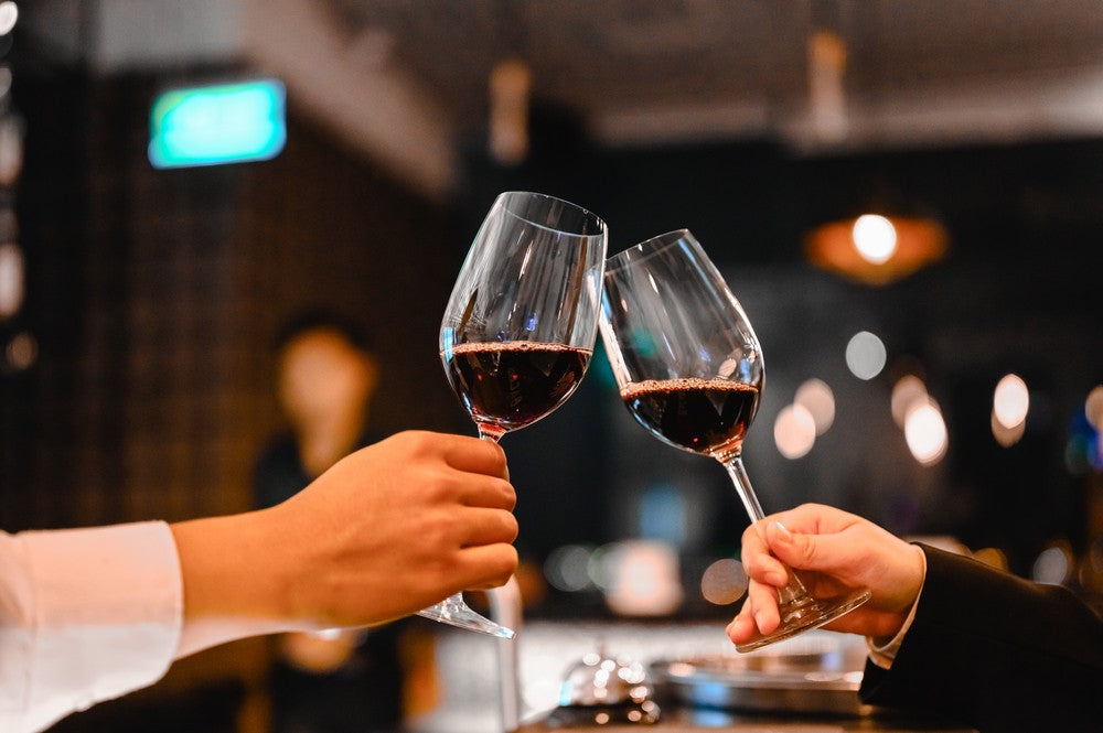 is red wine healthy – two people toasting with glasses of red wine