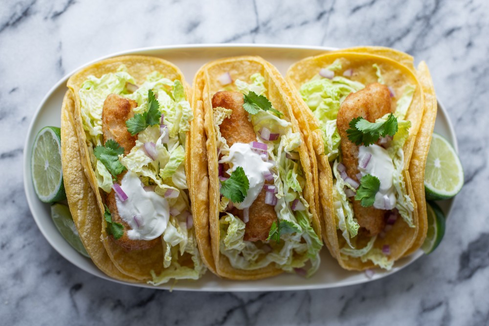 three fish tacos on white plate