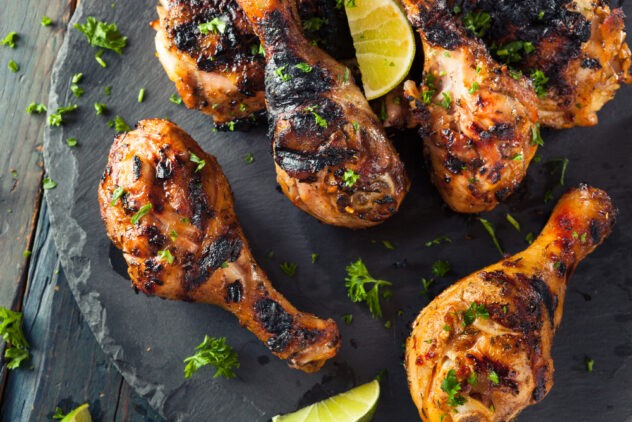 pairing wine with spicy food: close-up of grilled jerk chicken with limes and spices