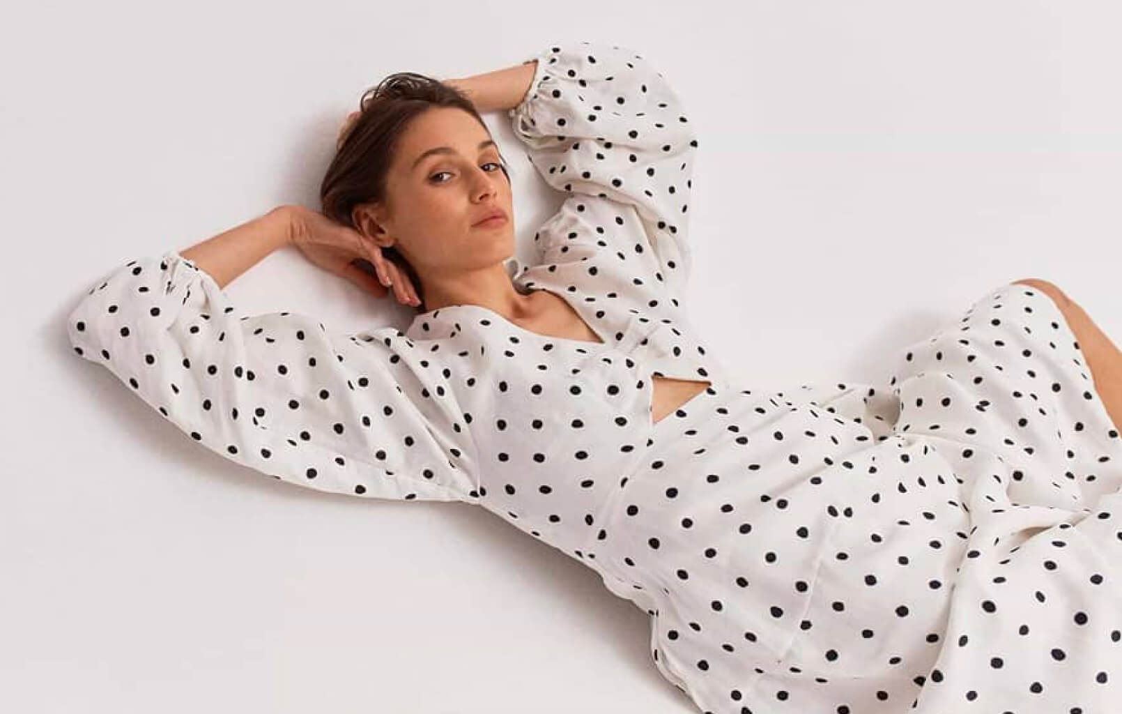 Woman laying down wearing polka dotted dress