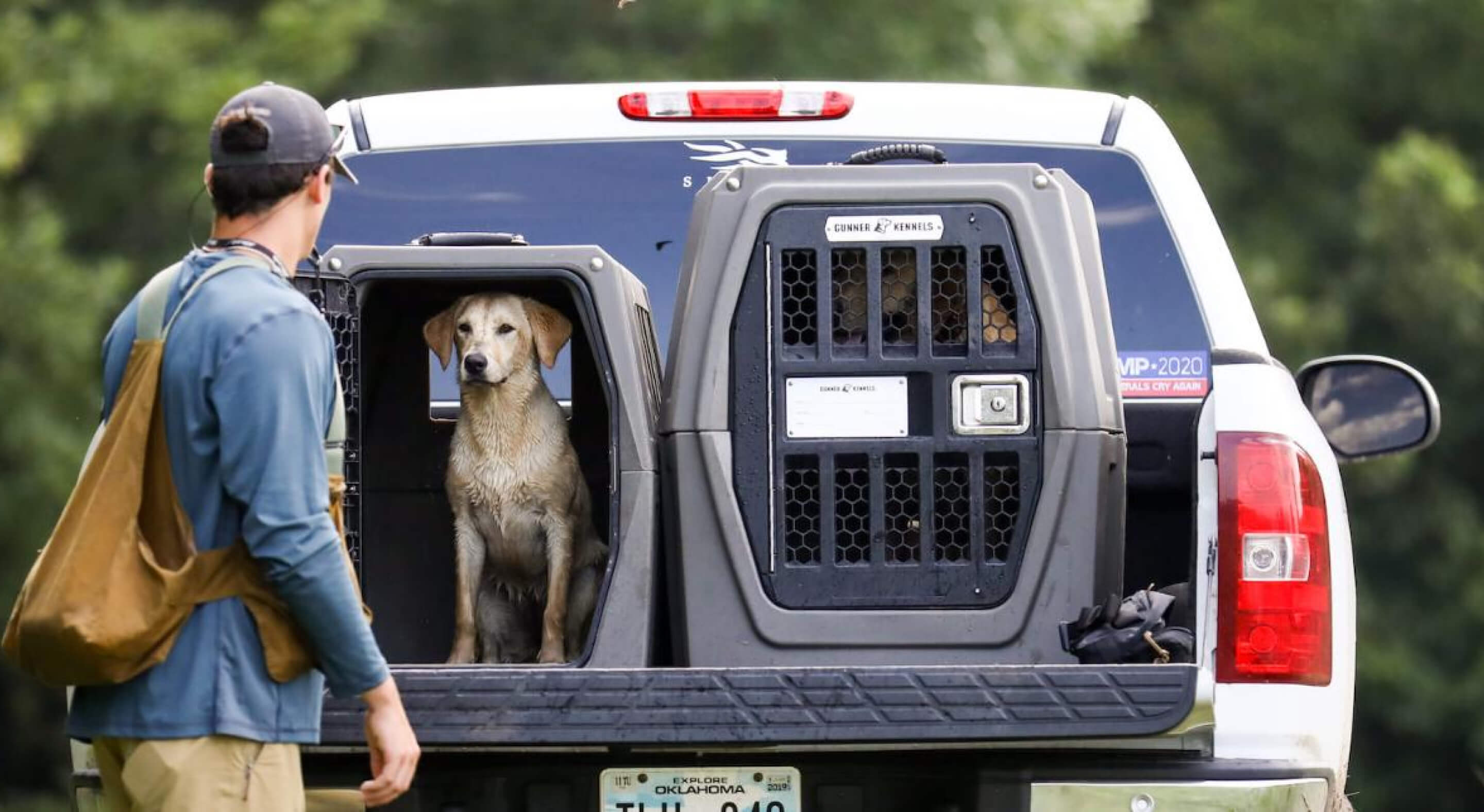 Two Gunner Kennels dog crates in the back of a white pickup truck.