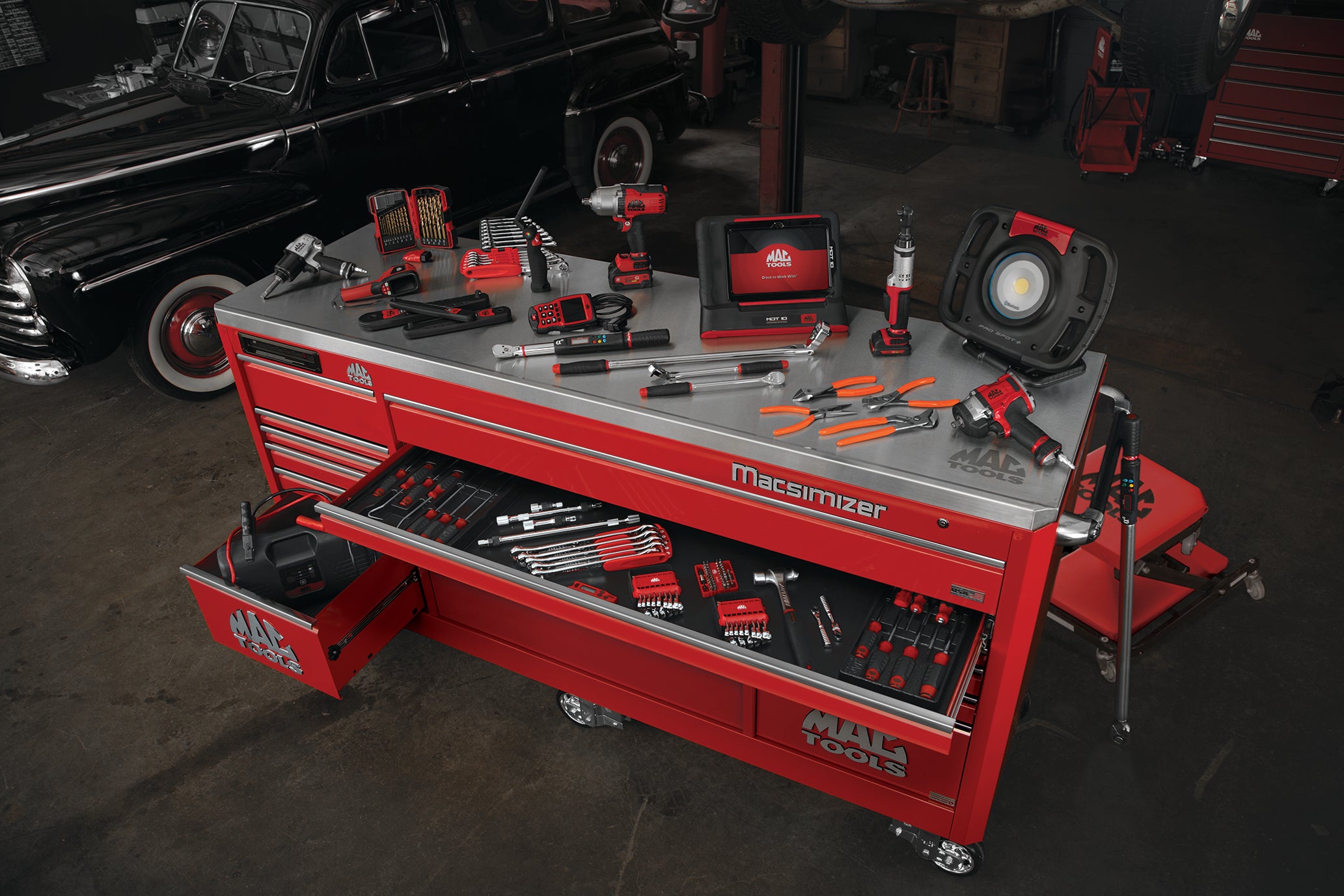 An assortment of Mac Tools displayed on top of a rolling tool cabinet