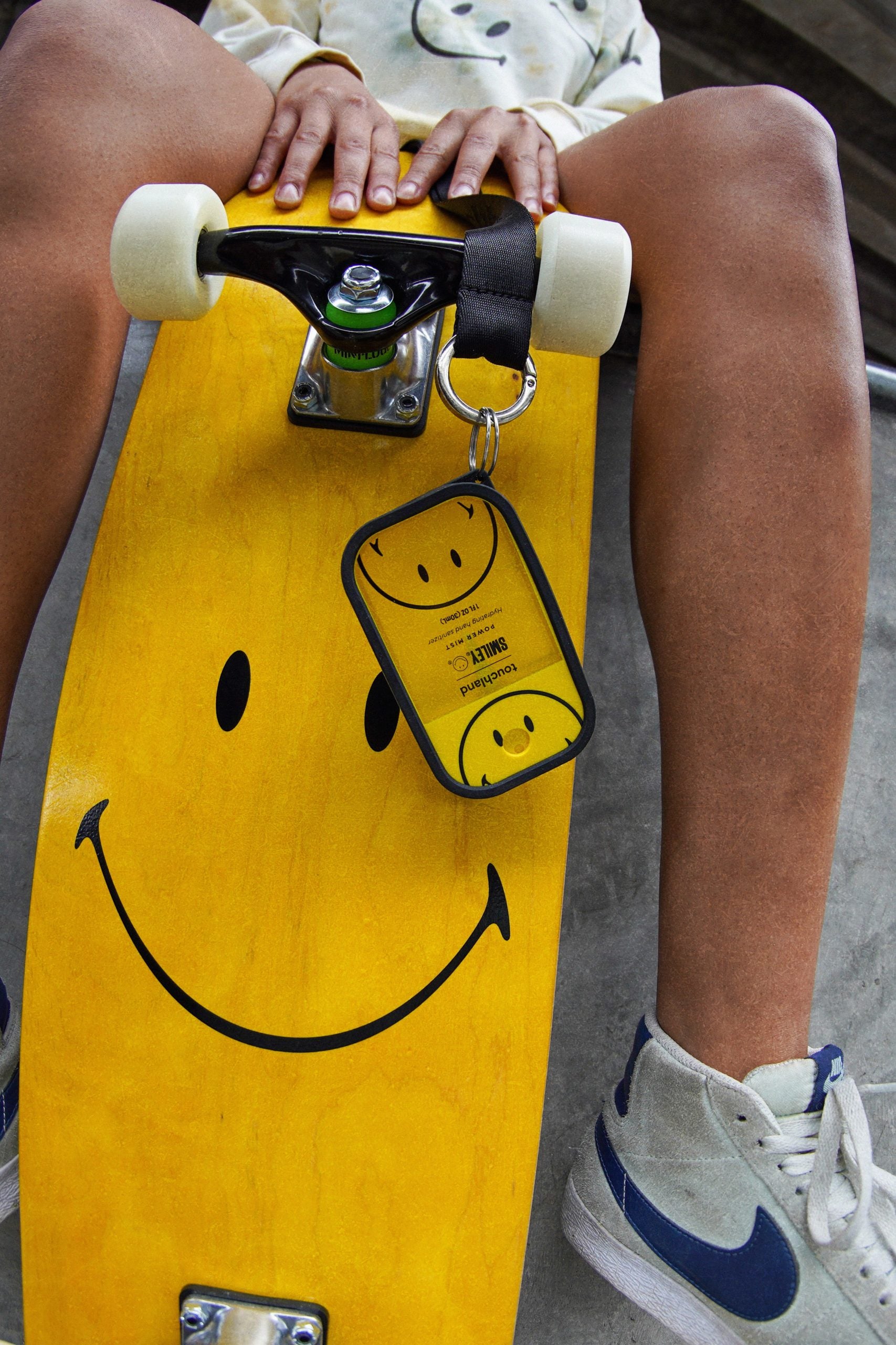 Touchland x Smiley hand sanitiser hooked on to a Smiley skateboard.