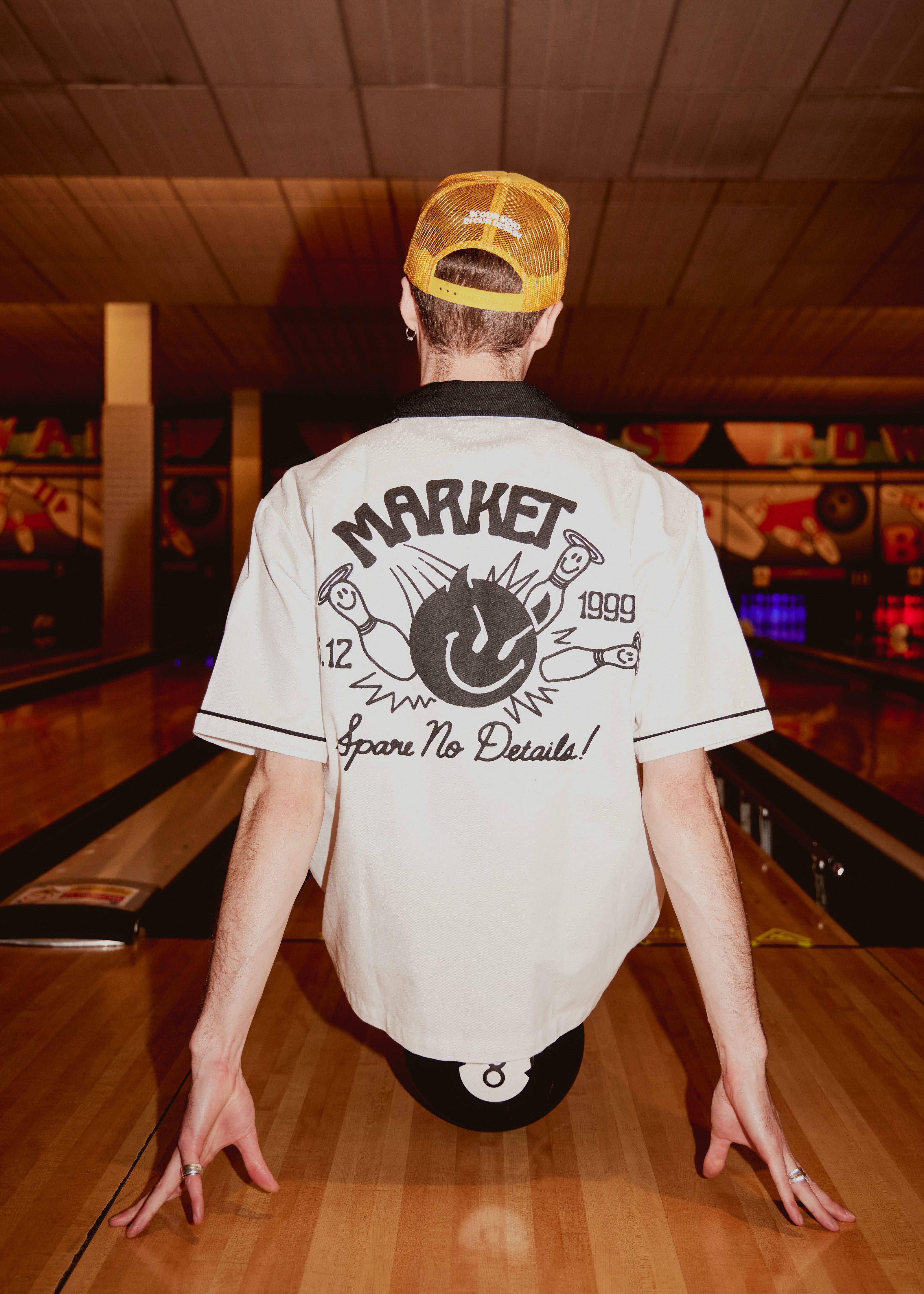 Jim from KAWALA sat on a bowling ball, wearing Market bowling shirt from the Smiley & Market collaboration.