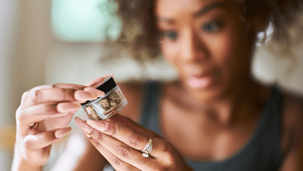 woman visually inspecting cannabis flower checking for mold