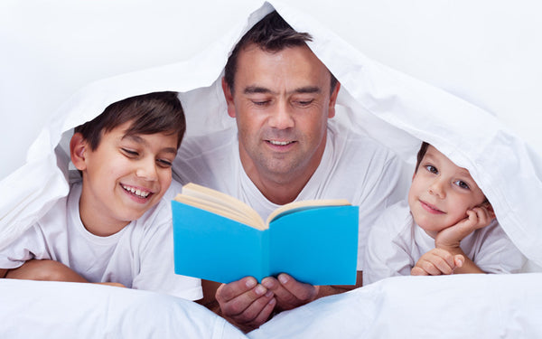 Eco-Friendly, Healthy Family Reading Under Organic Bedding