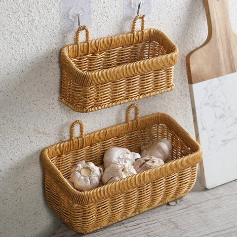 Two woven baskets hanging on a wall, one empty and one filled with garlic bulbs.