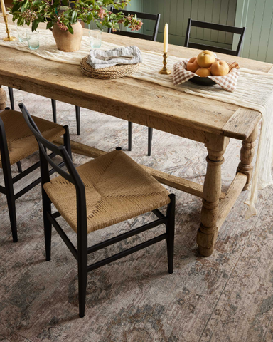 rustic dining room with wood table and chairs and blue area rug