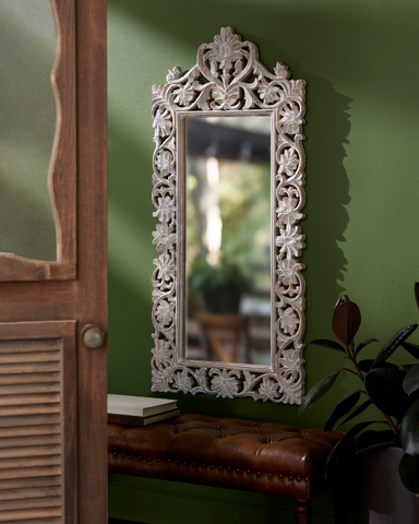 white framed mirror with detailing around the rim