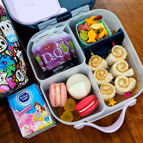 b.box mini lunchbox featuring peanut butter roll-ups, crackers, macarons, and yogurt